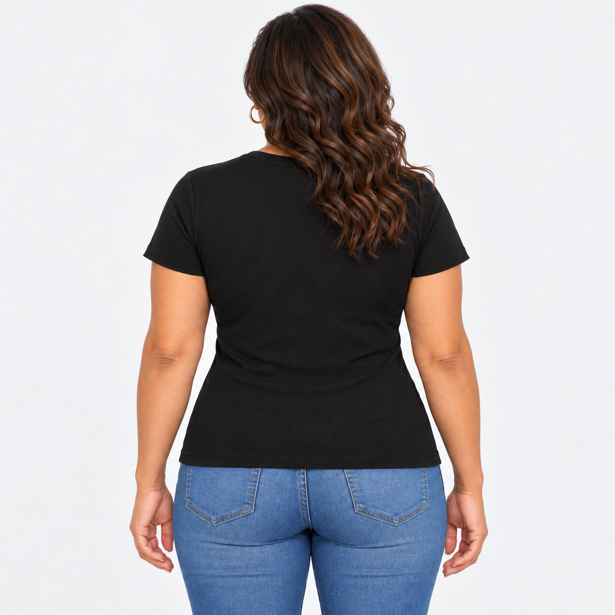 A woman viewed from the back wearing a fitted black short-sleeve t-shirt and blue jeans against a plain light gray studio background.