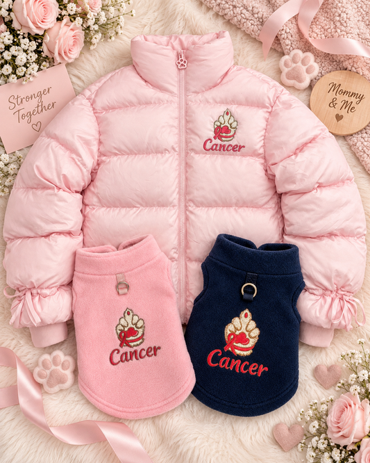 Pink puffer jacket with a embroidered dog paw with a pink ribbon around the wrist with the word cancer underneath the dog paw. A blue and a pink  dog fleece with a embroidered dog paw with the word cancer underneath the dog paw image.