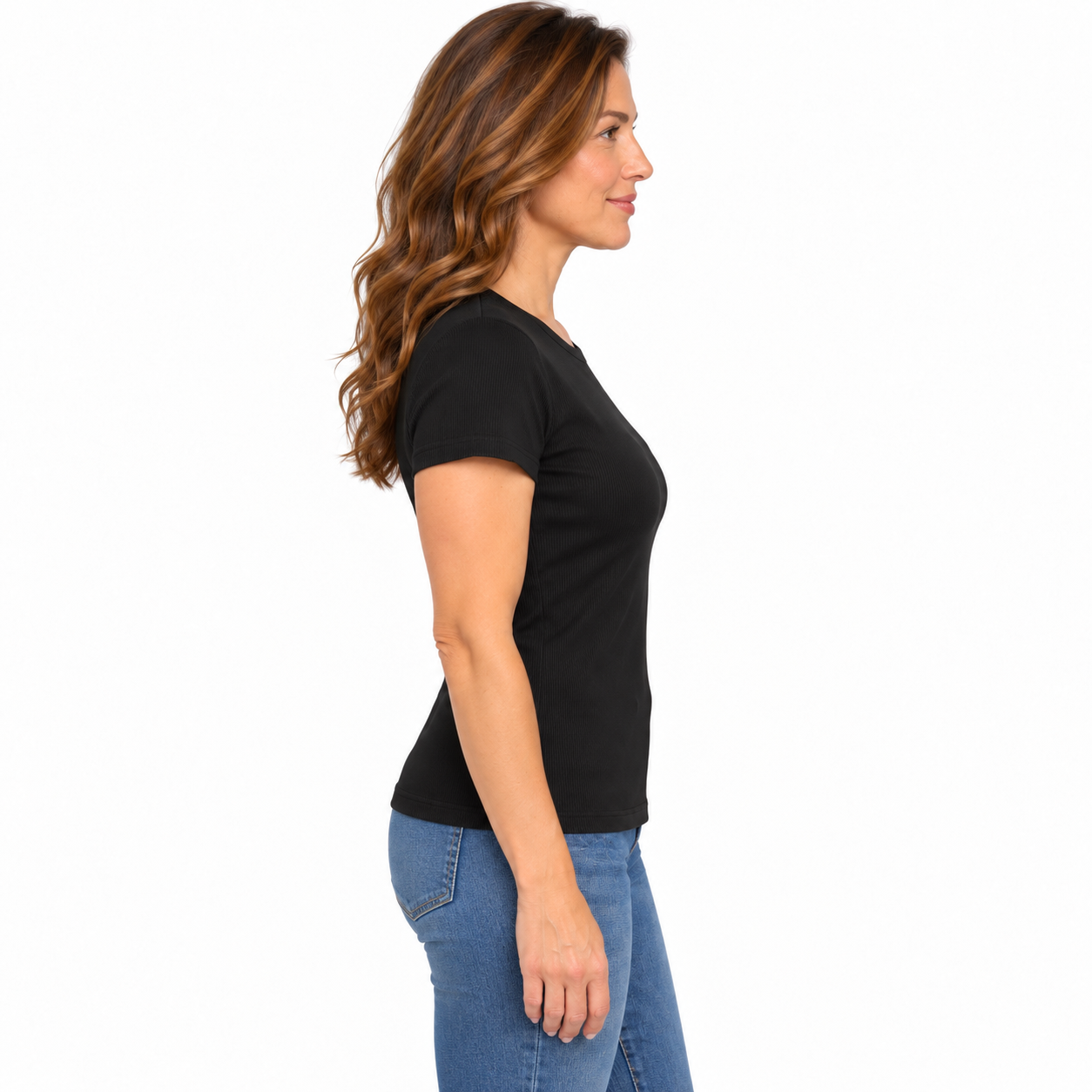 A woman shown in side profile wearing a fitted black short-sleeve crew-neck T-shirt and blue jeans against a plain white studio background.